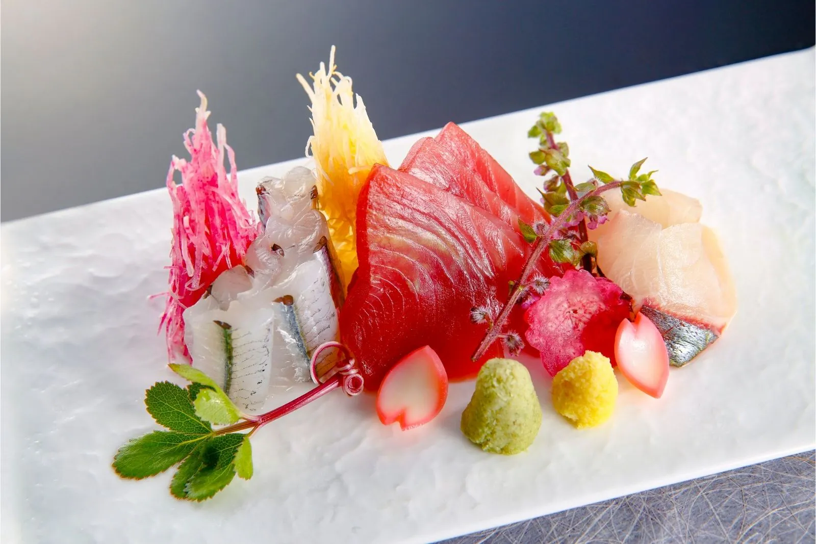 Artfully plated assorted premium raw fish sashimi garnished