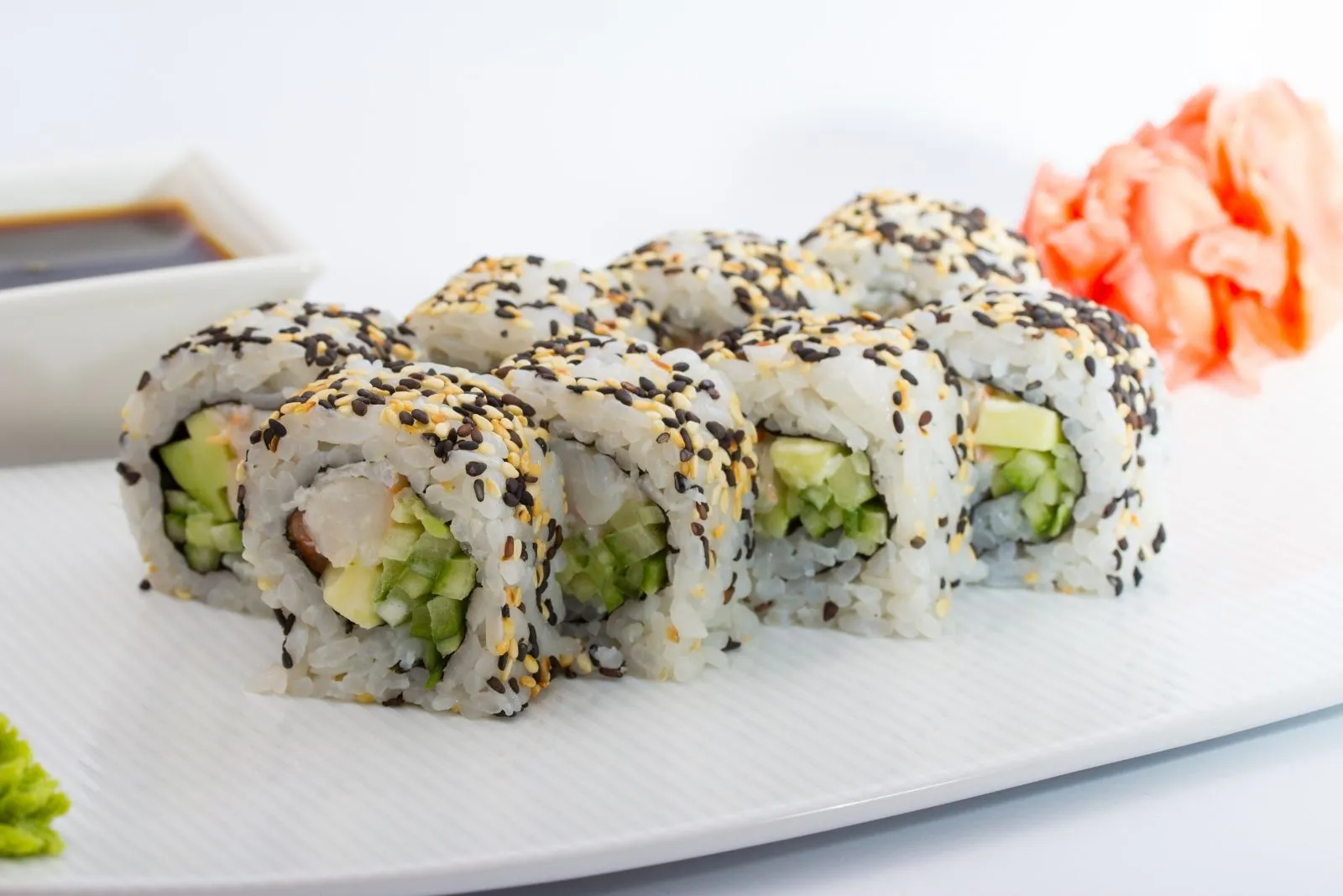 Shrimp avocado maki sushi roll covered with black sesame seeds